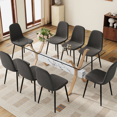 8 chaises en tissu de lin gris foncé avec des pieds en métal noir et un design de couleur unie pour l'ambiance de la maison, en plus de l'esthétique de la table de salle à manger en verre trempé transparent de 71 po x 35,4 po