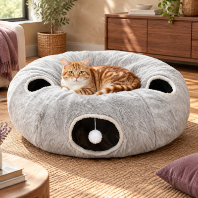Un tunnel en peluche gris en forme de beigne à 4 trous crée une grande cachette pour plusieurs chats, chatons, chiots et lapins ; il est décrit comme très doux et léger et est offert en cadeau avec 11 jouets pour chats.
