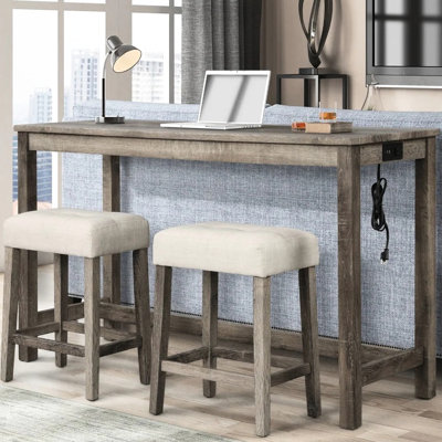 Ensemble bar rustique 3 pièces : table en bois massif avec prise électrique, 2 tabourets beiges rembourrés, idéal pour les repas intimes, revêtement en lin.