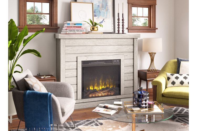 Living room with an electric fireplace that features wood paneling and a mantel shelf used to display artwork.