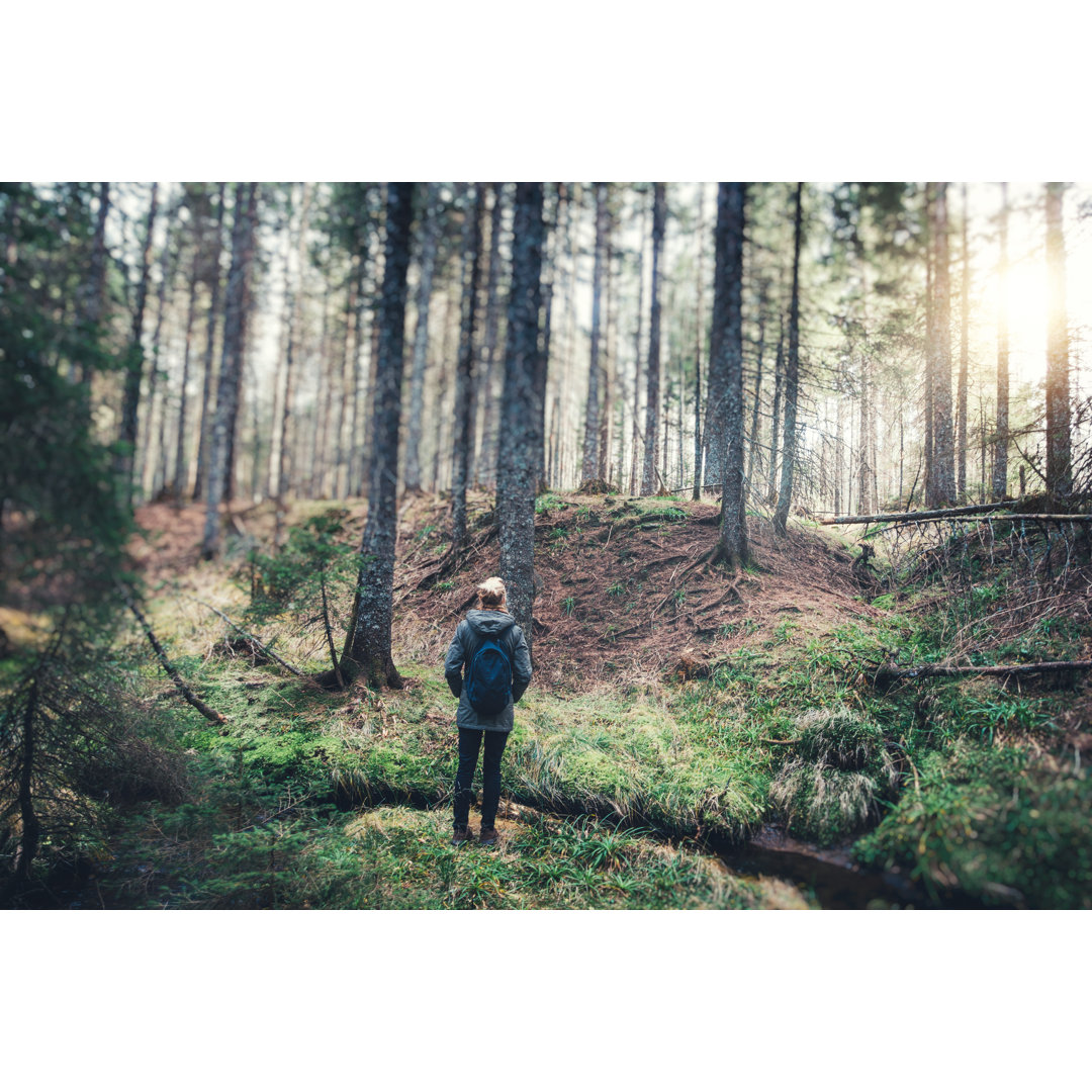 Frau mit Rucksack beim Wandern im Wald