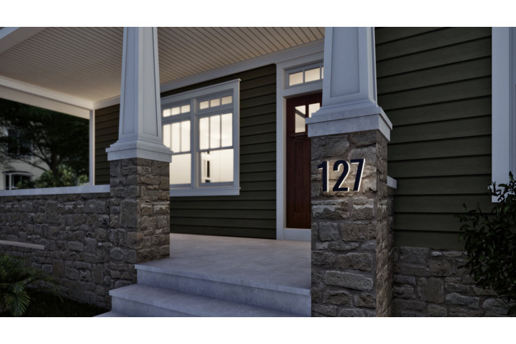 Floating house numbers installed on a stone pillar in front of a house front door