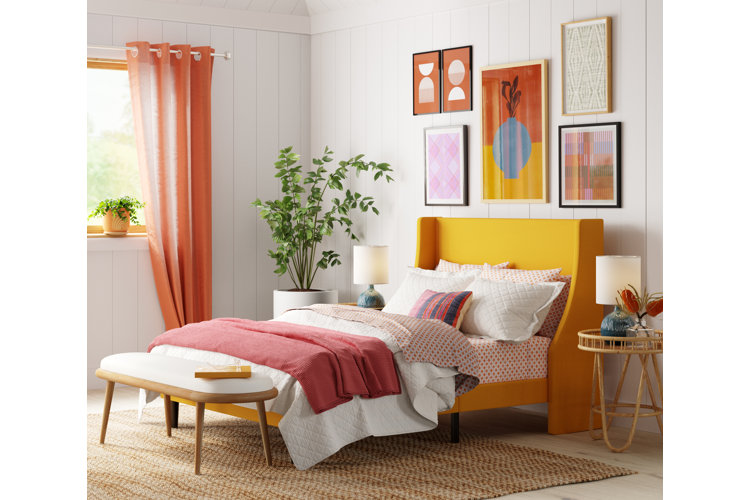 sunny bedroom with a yellow bed frame, array of bedding options, white shiplap wall, and white fabric and wood bedroom bench
