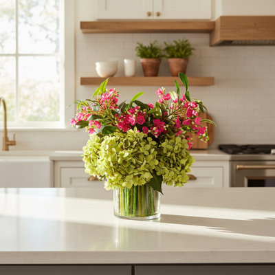 Hortensias et bourgeons dans un vase en verre