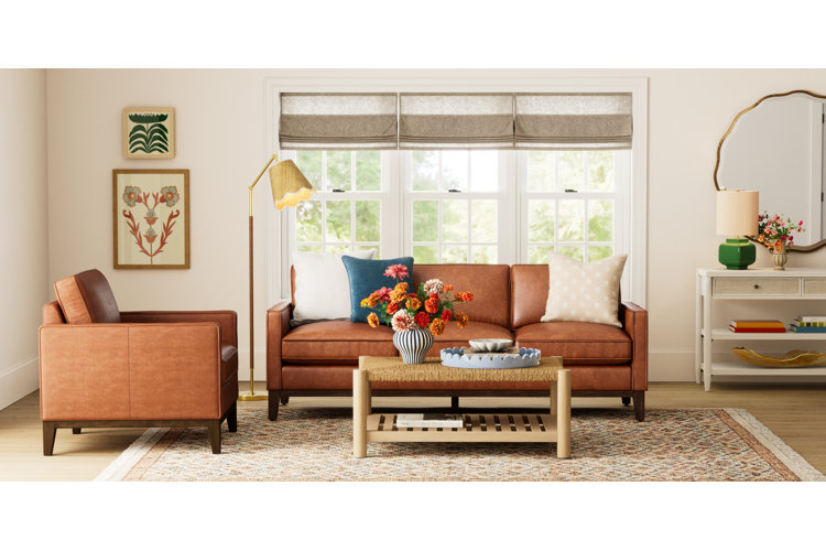 do i need a coffee table a transitional modern living room with a leather sofa, a leather accent chair and a rattan and wood coffee table on an area rug