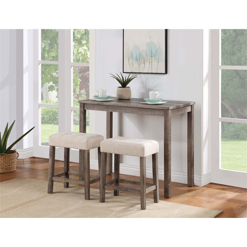 Ensemble de table bistro trois pièces à hauteur de comptoir avec tabourets capitonnés, idéal pour rehausser votre expérience de repas et de socialisation