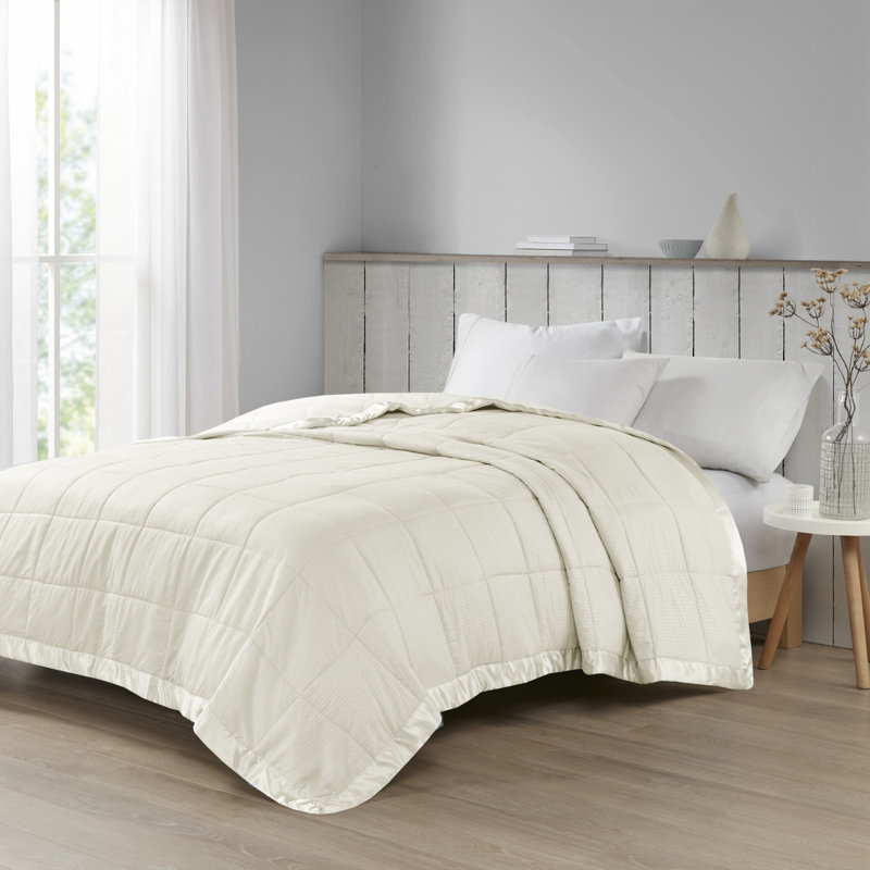 Couverture Madison Park Cambria surdimensionnée en ivoire, style duvet synthétique, avec bordure en satin., Roi, Ivoire