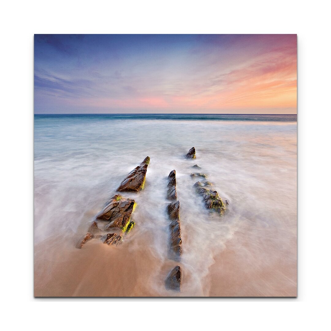 Leinwandbild Sandstrand mit spitzen Steinen