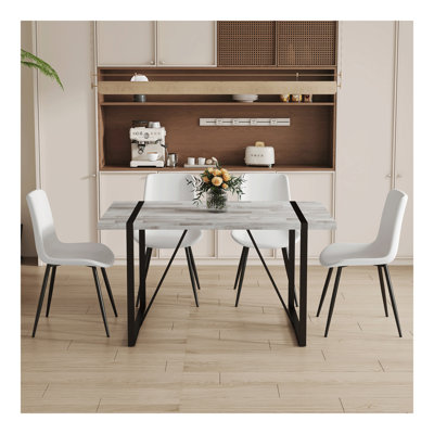 Ensemble de table et de chaises.Une table de salle à manger rectangulaire rétro minimaliste avec un dessus spécialement texturé et des pieds en métal noir.