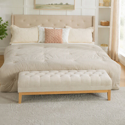 Pouf d'appoint capitonné en chenille de 160 cm de large, avec pieds en hévéa naturel, repose-pieds et assise rembourrée. Parfait pour une entrée, un salon, une chambre, une salle à manger ou un couloir. Couleur blé.