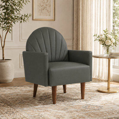 A contemporary shell-shaped armchair with PU leather upholstery and wooden legs, suitable for living rooms, balconies, children's rooms and studies
