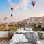 Montgolfière survolant un paysage de roches à la Cappadoce, Turquie-93997397