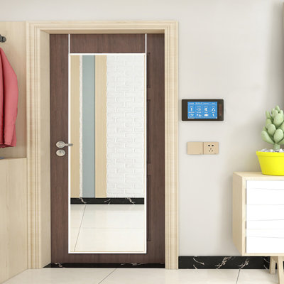 White full-length mirror with frame behind door