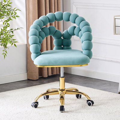 Chaise de loisirs en velours bleu sarcelle avec roulettes dorées à cinq griffes pour une mobilité douce et un confort luxueux dans le salon ou le bureau à domicile.