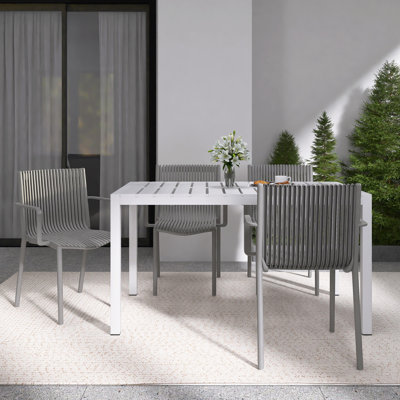 4-Person Patio Dining Set with White Rectangular Table, Stackable Polypropylene Armchairs for Indoor/Outdoor Use