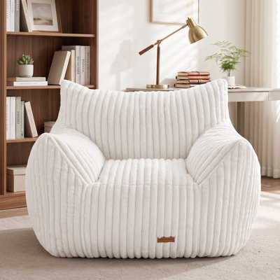 Le pouf de compression est offert en format spacieux et est accompagné d'un canapé deux places en fausse fourrure.