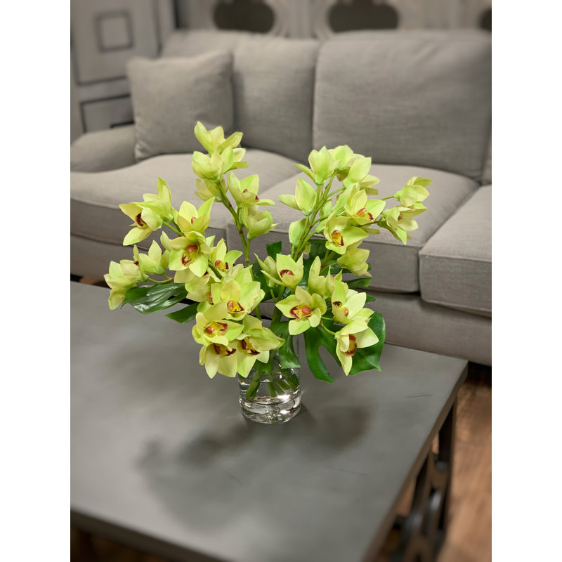Orchids And Leaves In A Glass Vase
