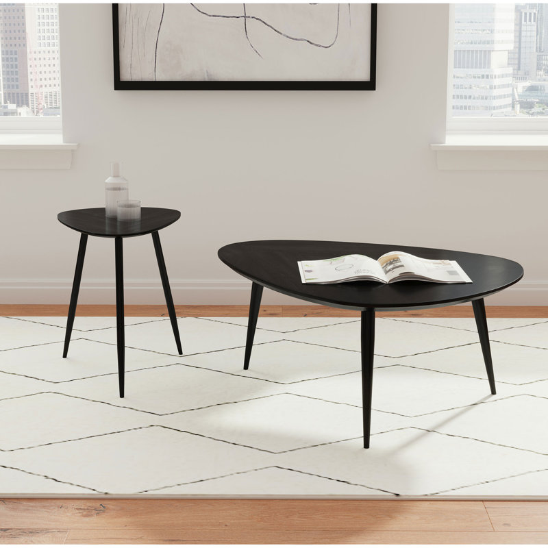 Table basse triangulaire en bois massif noir, de style artisanal, avec finition noire, coins légèrement arrondis et pieds en fer évasés.