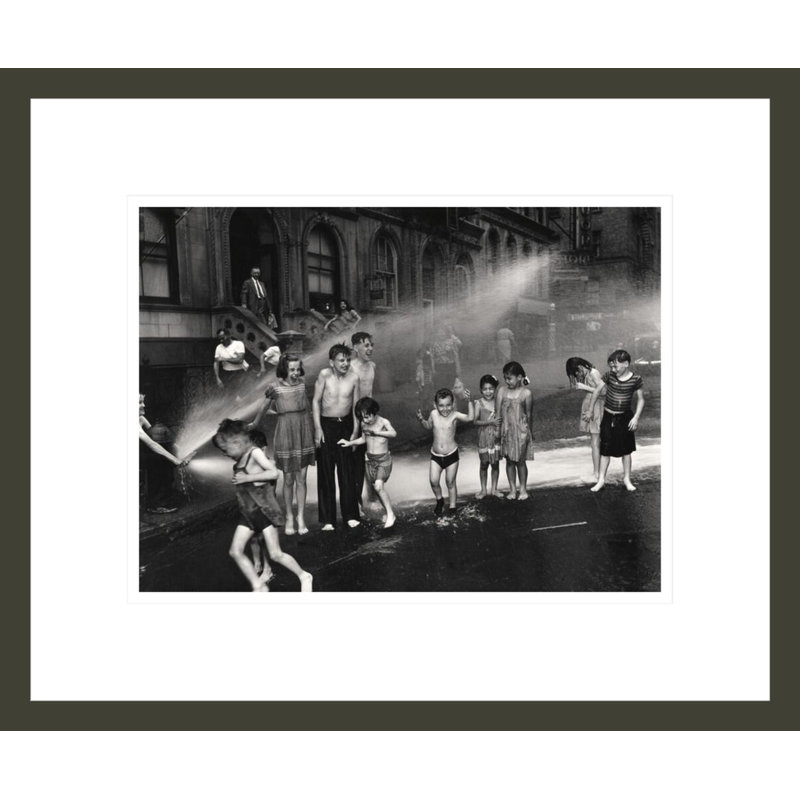 [Enfants jouant dans de l'eau pulvérisée à partir d'une bouche d'incendie à ciel ouvert de l'Upper West Side à New York] par Weegee - Impression giclée encadrée