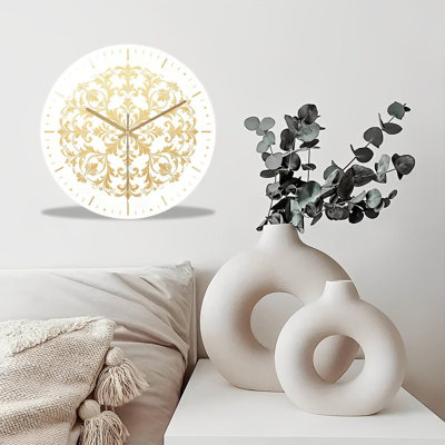Cette horloge murale de 30 cm en verre trempé présente un délicat motif radial doré. Dotée de chiffres dorés sobres et d'un mouvement à quartz silencieux, cette horloge 2D est un élément de décoration moderne et épuré, idéal pour les salons, les bureaux et les intérieurs minimalistes.