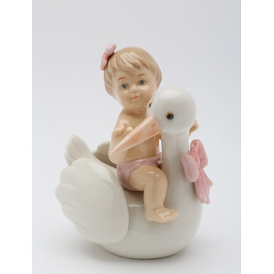 Figurine bébé sur une cigogne