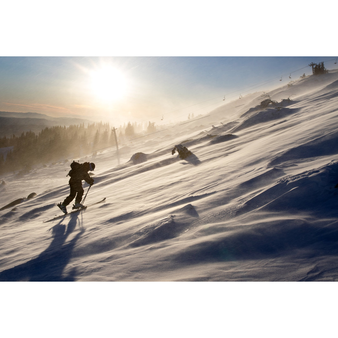 Ein Skifahrer klettert in den frühen Morgenstunden einen Berghang hinauf