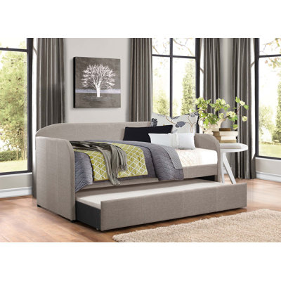 Lit de jour de conception moderne avec revêtement en tissu gris, panneau arrière en forme d'arche et lit gigogne escamotable pour une utilisation polyvalente