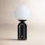 Table lamp with a spherical white glass shade on a cylindrical black marble base.