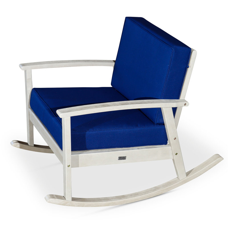 Chaise berçante en eucalyptus avec coussins bleu marine décontractés, surface grise en bois flotté pour un patio luxueux