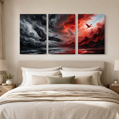 Ensemble de 3 grues noires et blanches survolant un ciel gris orageux et rouge vif