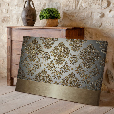 La toile crée un design de papier peint élégant avec un motif damassé complexe en or chatoyant contre un taupe doux