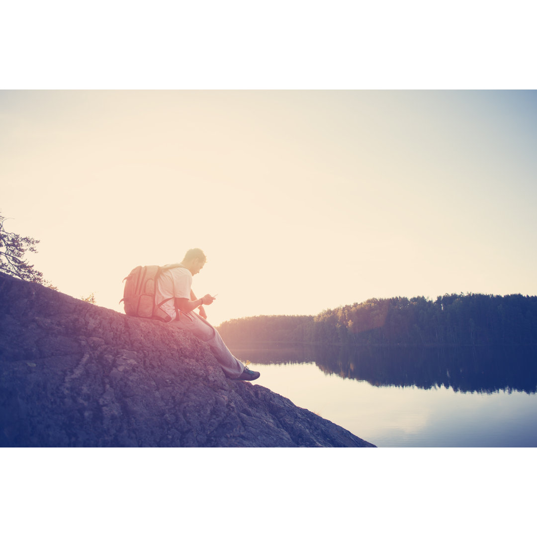 Leinwandbild Tourist mit Mobiltelefon und Rucksack