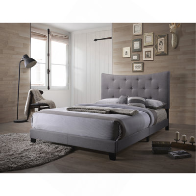 Grand lit gris avec tête de lit capitonnée