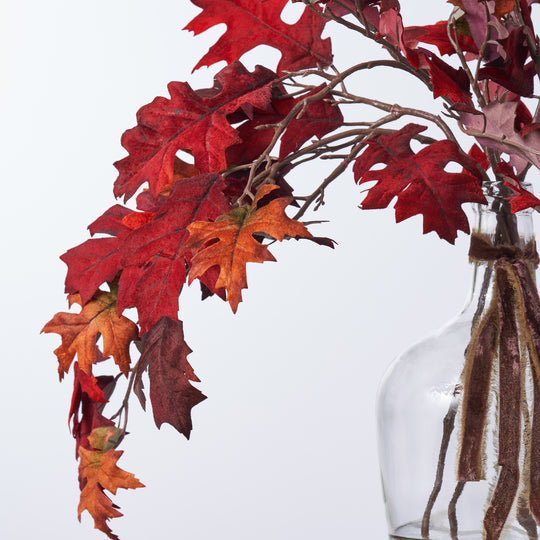 Branches de feuilles de chêne en velours rouge bourgogne d'automne réalistes dans un vase en verre
