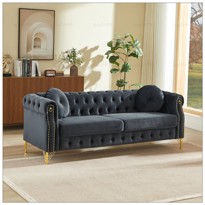 Luxurious Velvet Chesterfield Sofa With Tufted Buttons, Copper Studs, And Hanging Ornament Design For Elegant Living