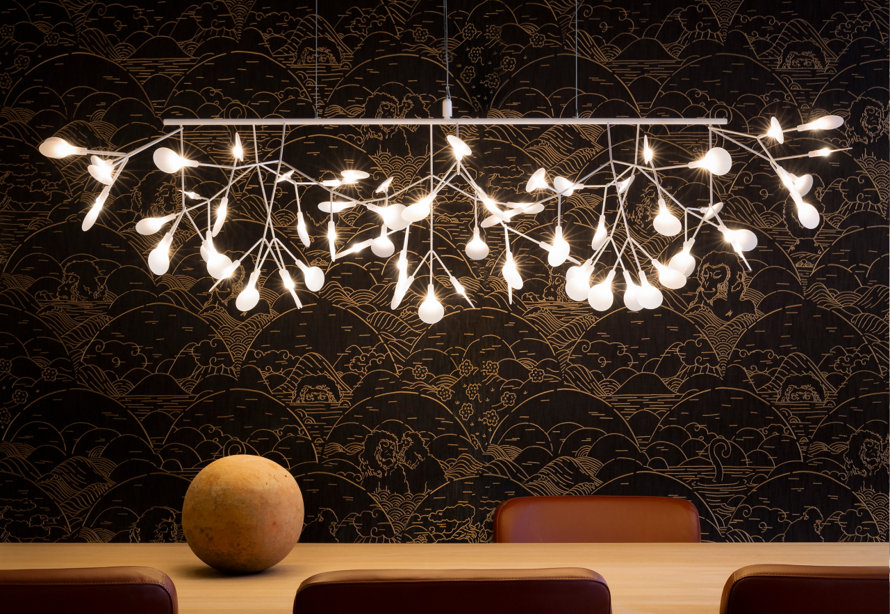Dining room with branch chandelier, decorative wallpaper, table, and chairs.
