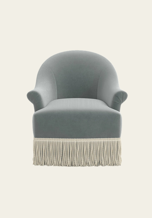 Gray barrel armchair with fringe trim.