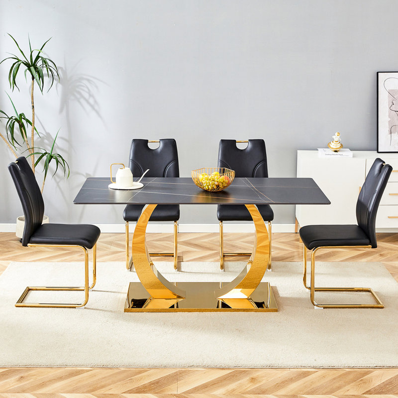Table 63 po x 31,5 po avec plateau en pierre frittée. Jumelé 4 chaises noires avec pieds dorés. Dessus pour la maison et chaises modernes. Essentiels