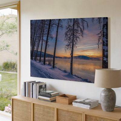 Toile, "Un paysage d'hiver serein au lever du soleil avec de grands arbres élancés ornés de neige blanche fraîche"