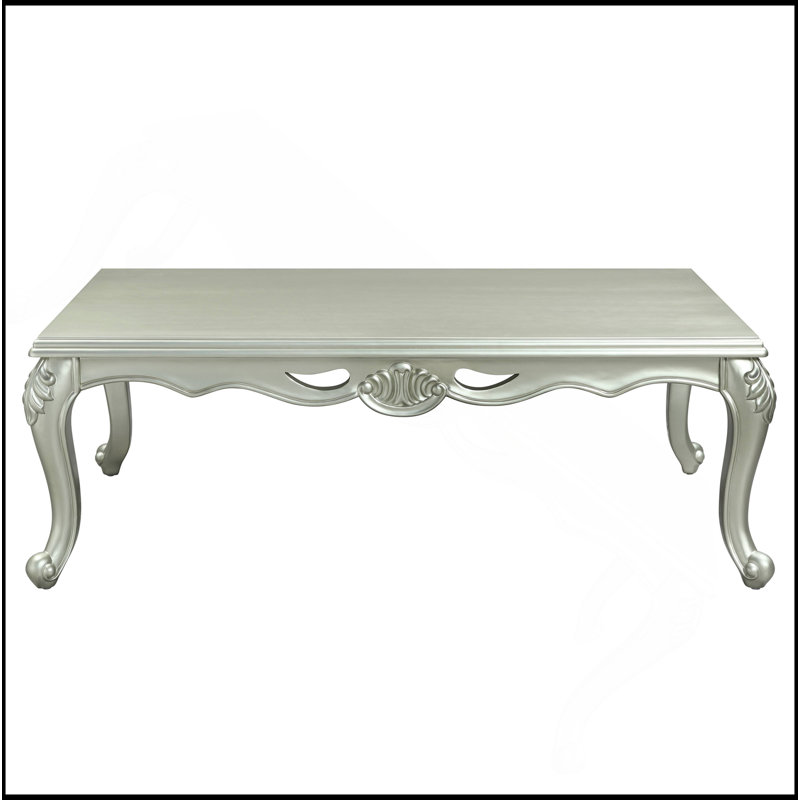Table basse champagne avec des courbes gracieuses et des motifs floraux complexes