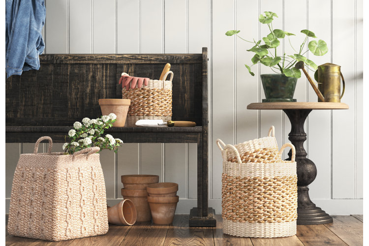 A wooden bench with wicker baskets and houseplants