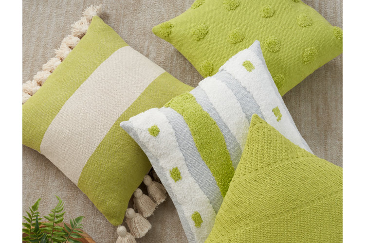 Assortment of four chartreuse-colored throw pillows displaying different patterns including stripes and polka dots.