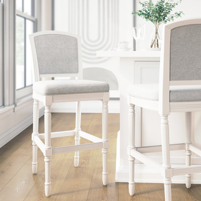Tabouret de bar de 31 po de hauteur blanche avec siège et dossier rembourrés gris, pieds tournés texturés et ornés pour l'assise, cuisine design