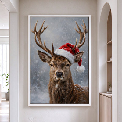 Cerf de Noël portant un bonnet de père Noël sous la neige, tableau sur toile encadré, cadre blanc, 50 x 75 cm