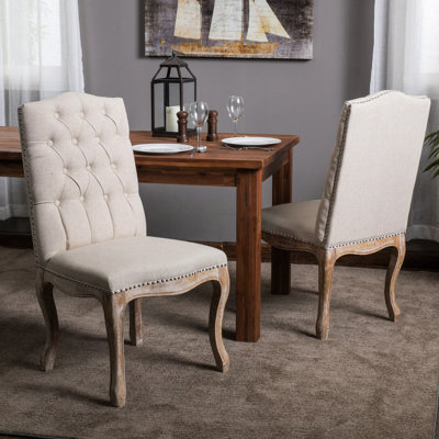 Chaise de salle à manger en tissu beige avec 2 chaises, bordure cloutée, assise en bois patiné, base élégante