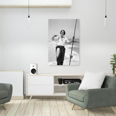 1920s 1930s SMILING WOMAN STANDING IN OCEAN SURF WEARING RUBBER WADERS HOLDING FISH AND FLY FISHING ROD by H. Armstrong Roberts - Wrapped Canvas Print