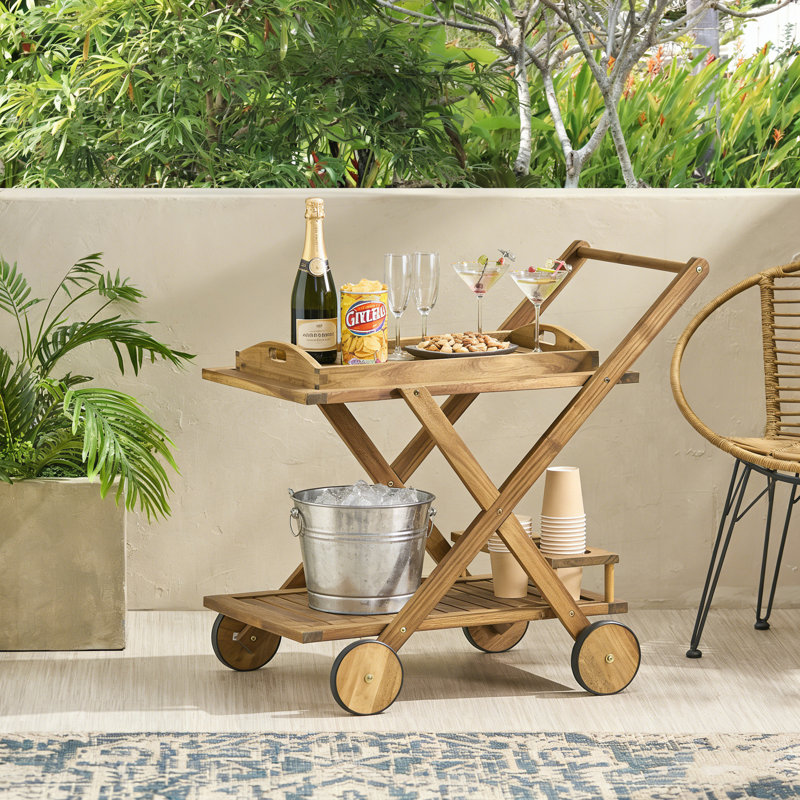 Chariot-bar RIVIERA avec roues mobiles et fabrication en bois d'acacia naturel pour un divertissement élégant et un rangement flexible.
