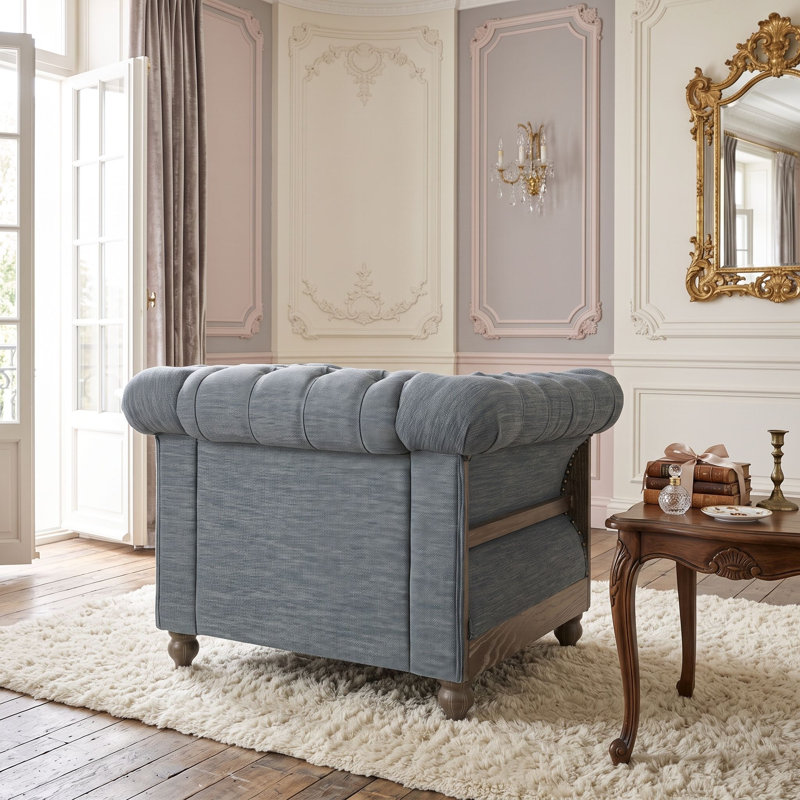 Fauteuil club capitonné avec garniture cloutée