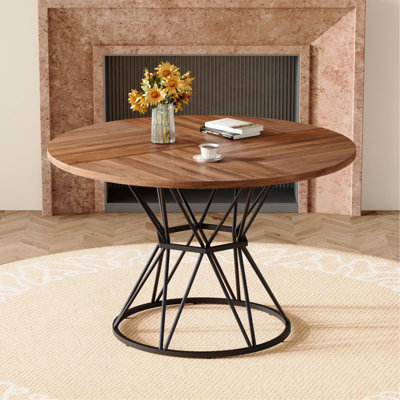 Une table de salle à manger circulaire d'un diamètre de 47,3 pouces, comprenant 4 plateaux de table en bois aggloméré noyer, des supports en métal en forme de sablier et une table de salle à manger de style industriel moderne pour 4 à 6 personnes.