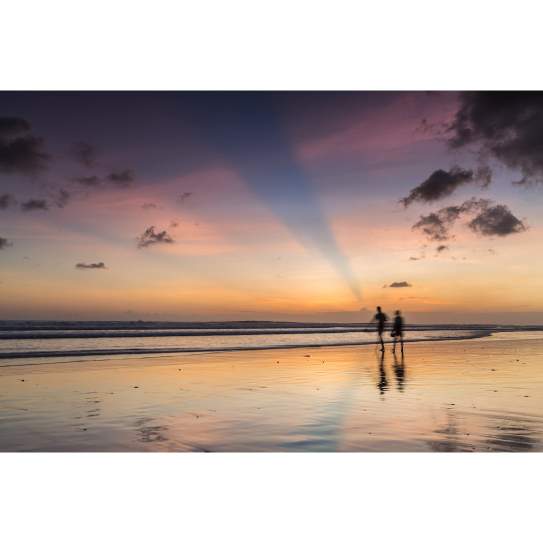 Ein Paar geht bei Sonnenuntergang am Strand spazieren